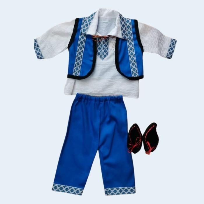 Costumul este compus dintr-o vestă albastră cu dungă neagră dantelată, o cămașă albă cu rever și grilaj albastru la gât, piept și mâneci, un brâu tricolor, pantaloni comozi cu elastic în talie și botosei negri cu mătase roșie la închidere. Disponibil în mărimi de la 1-3 luni și 3-6 luni, acest costum este perfect adaptat nevoilor copiilor mici.